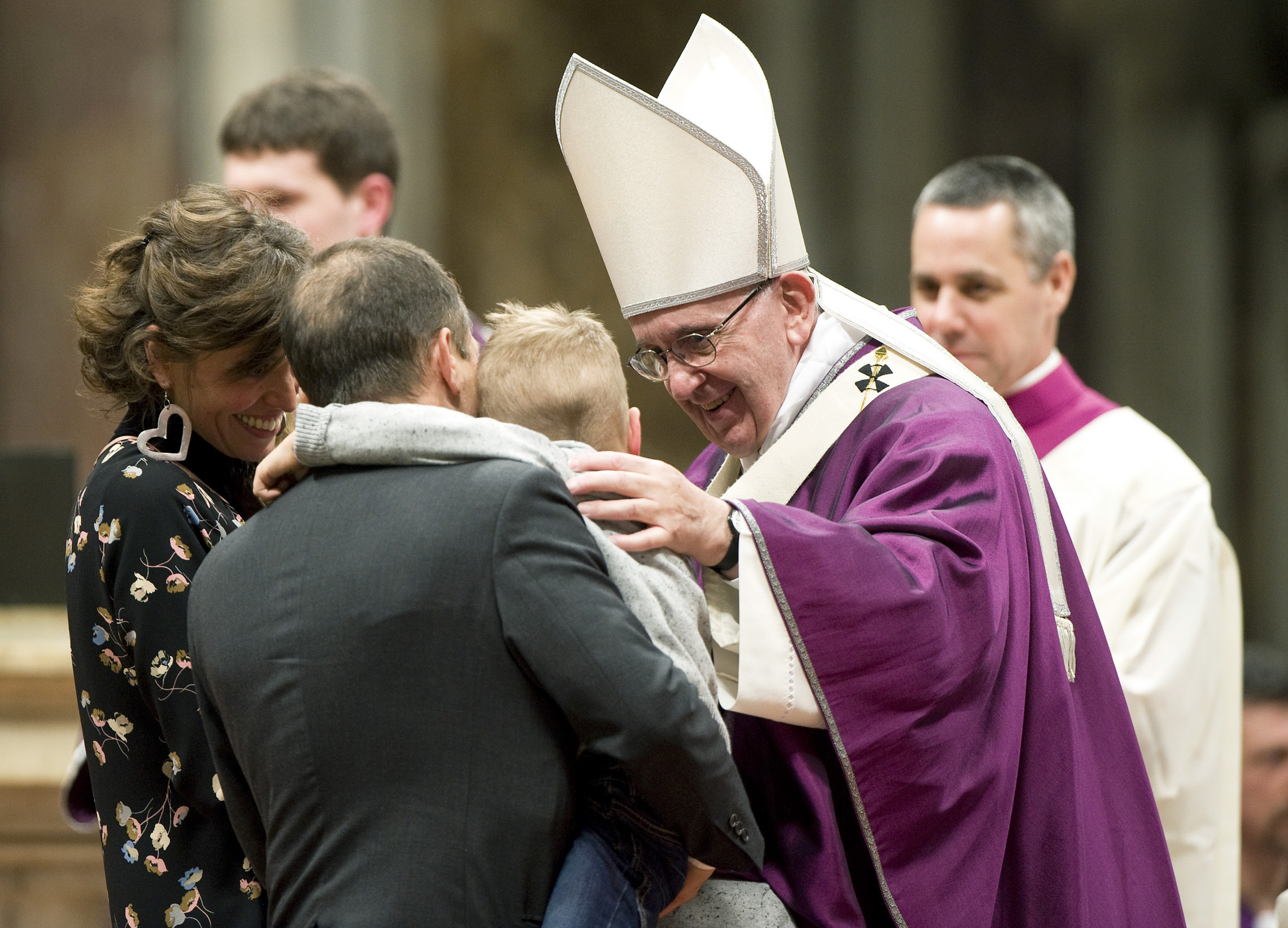Le pape François félicitant une famille, lors de la messe du mercredi des cendres, en février 2016 à Rome.